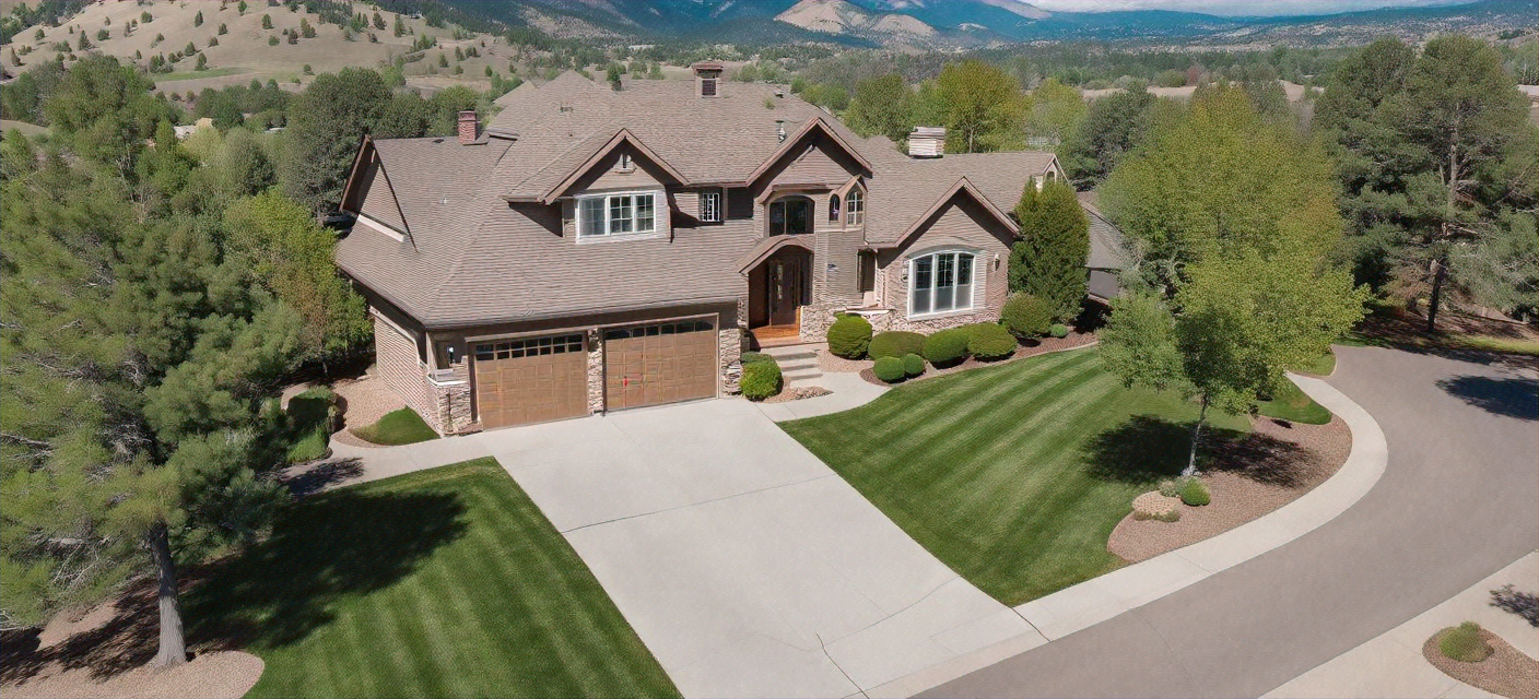 Aerial view of a luxury Boulder Colorado home with landscaped yard and driveway